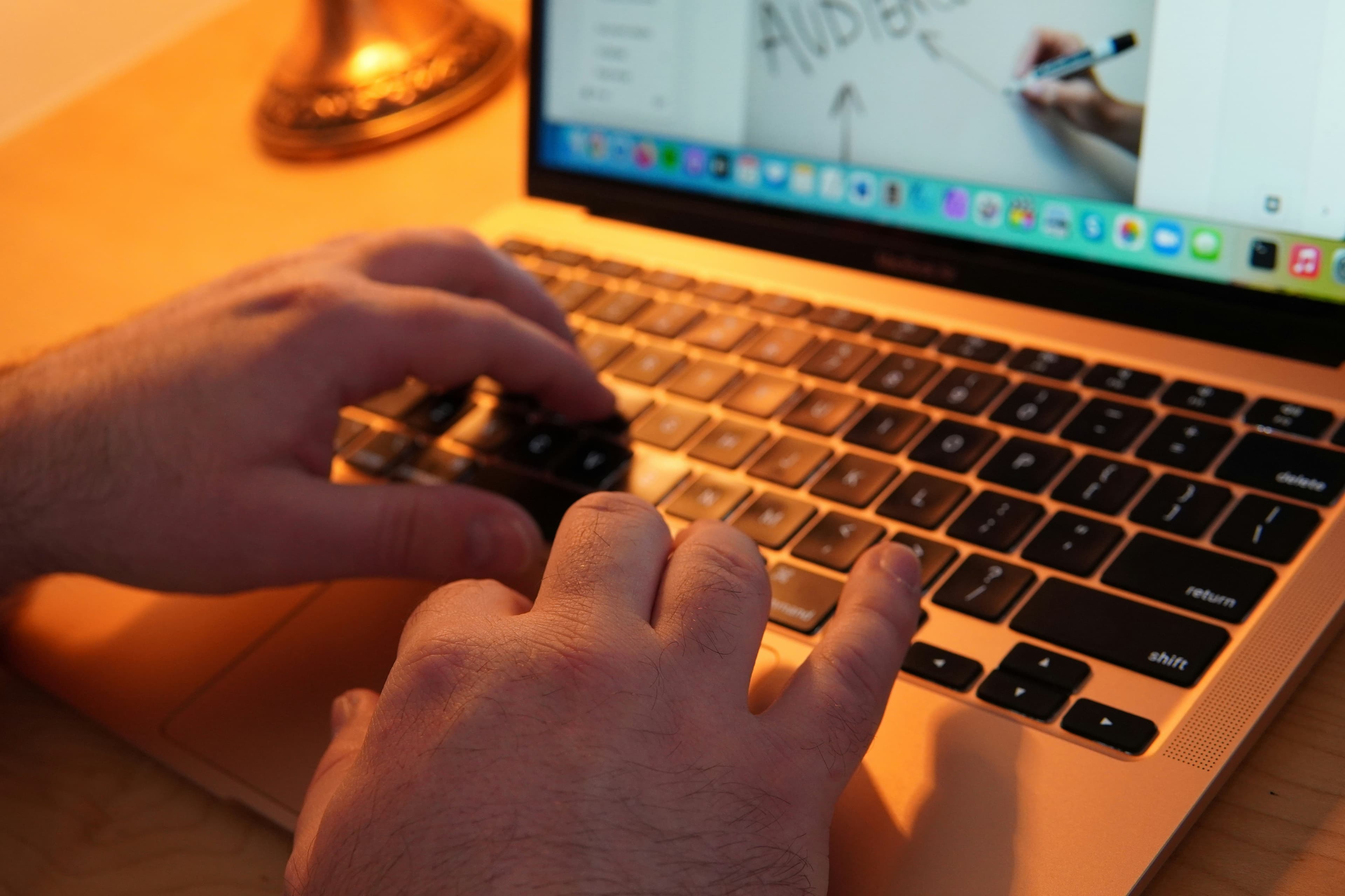 Close-up of hands actively typing on a laptop keyboard
