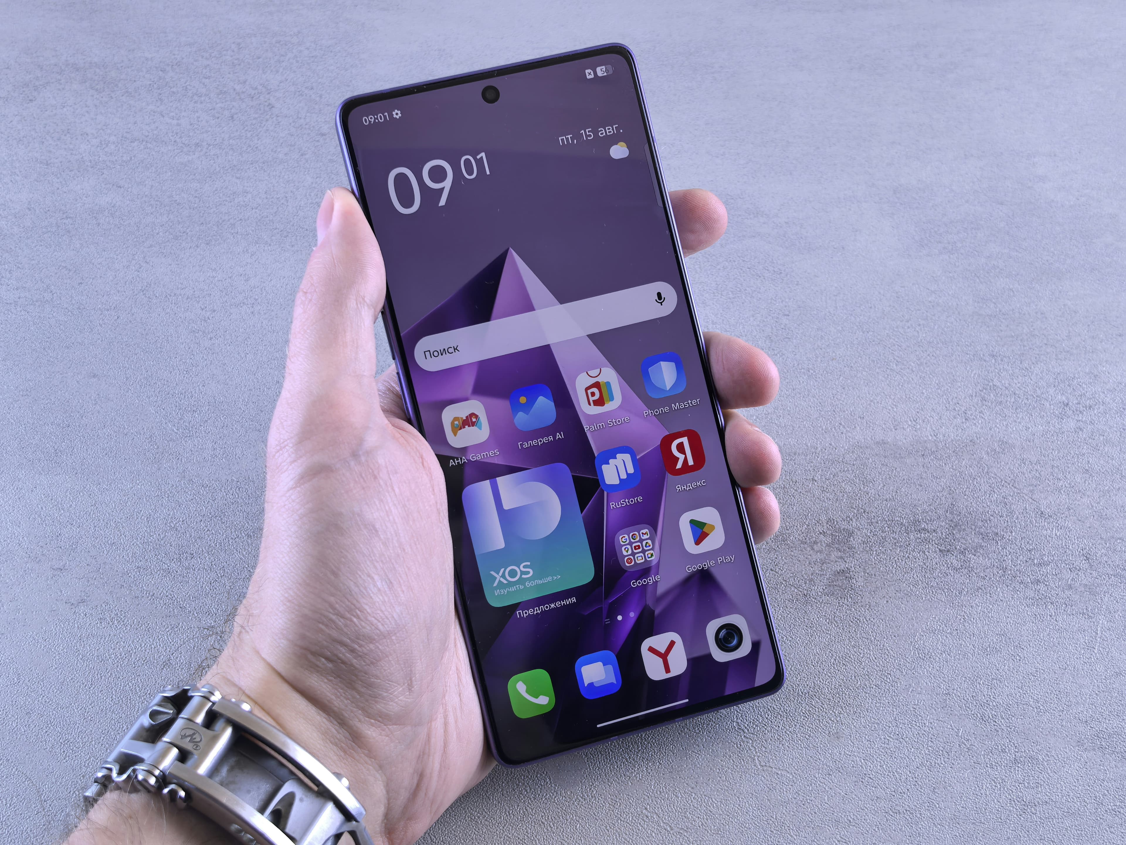 Hand holding a smartphone displaying a colorful grid of app icons on the screen